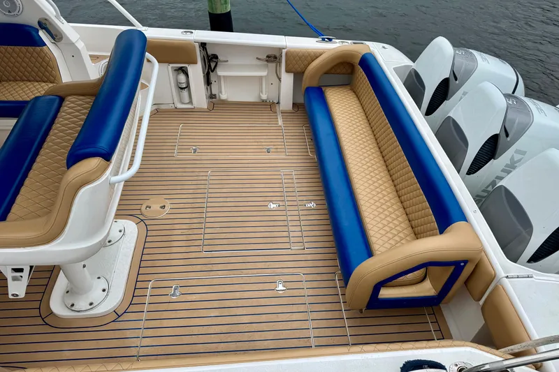 Slide: The Image of 2012 Intrepid 390 Sport Yacht deck with blue and tan seating, featuring Suzuki outboard engines. - 6