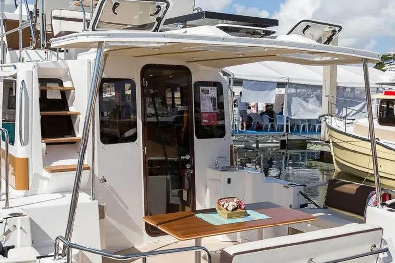 Slide: The Image of 2016 Ranger Tugs R-31 CB boat with outdoor seating and table at a marina. - 11