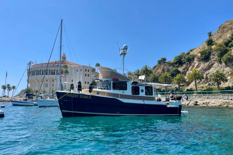 Slide: The Image of 2016 Ranger Tugs R-31 CB boat anchored near scenic coastal building and palm trees. - 13