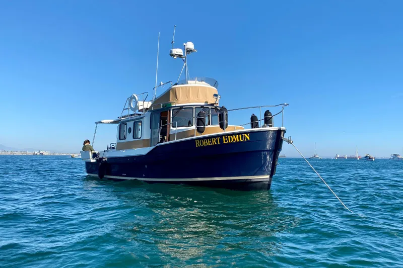 Slide: The Image of 2016 Ranger Tugs R-31 CB boat named "Robert Edmun" anchored on calm blue water. - 14