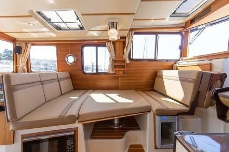 Slide: The Image of Interior of 2016 Ranger Tugs R-31 CB with beige seating and wood accents. - 4