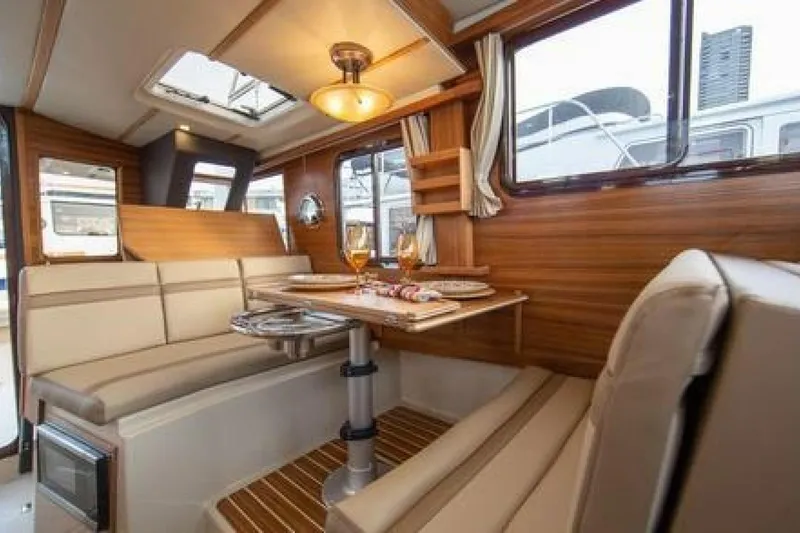 Slide: The Image of Interior of 2016 Ranger Tugs R-31 CB with cozy dining area and elegant wood finish. - 6
