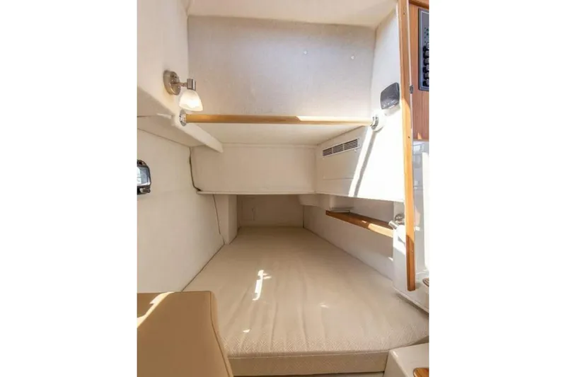 Slide: The Image of 2016 Ranger Tugs R-31 CB cabin interior with cozy sleeping area and wooden accents. - 8