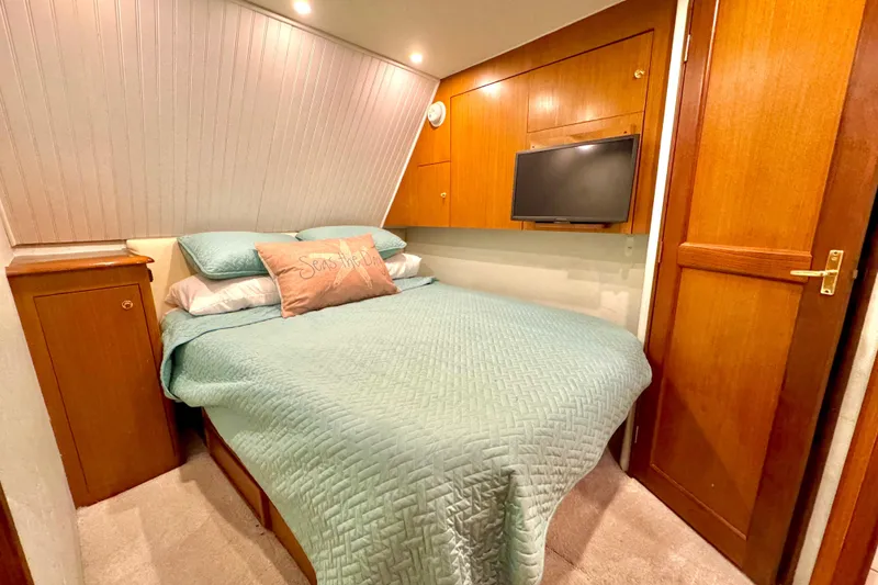 Slide: The Image of Cozy bedroom in 1998 Ocean Yachts 48 Super Sport with teal bedding and wood accents. - 16