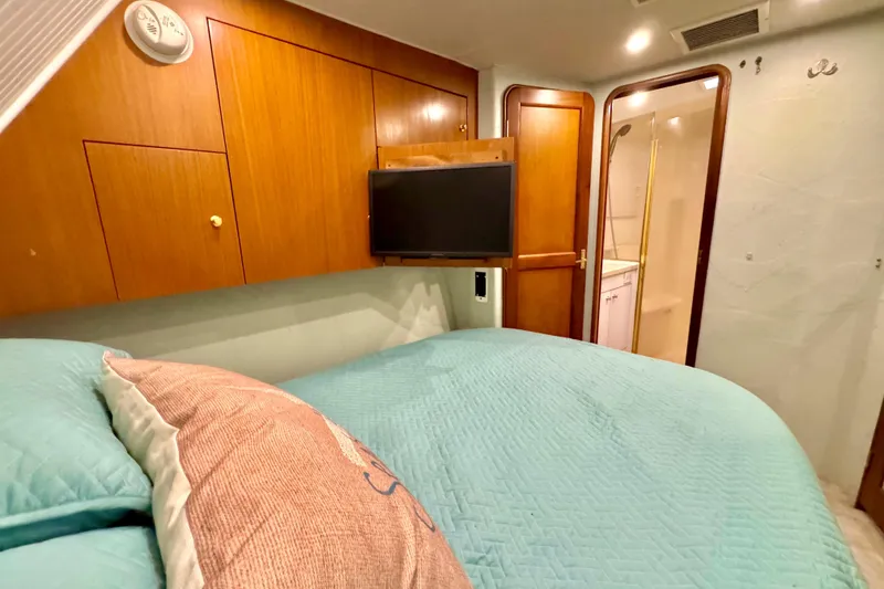 Slide: The Image of Cozy bedroom in 1998 Ocean Yachts 48 Super Sport with wood cabinetry and ensuite bathroom. - 17