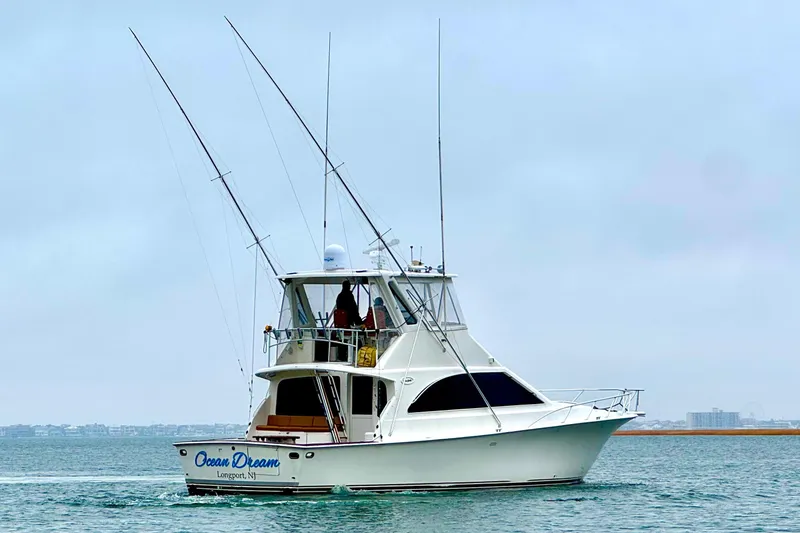 Slide: The Image of 1998 Ocean Yachts 48 Super Sport cruising on calm waters under a cloudy sky. - 2