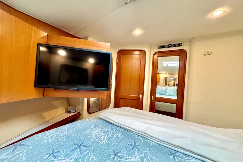 Slide: The Image of Interior of 1998 Ocean Yachts 48 Super Sport with TV and cozy bedding. - 22