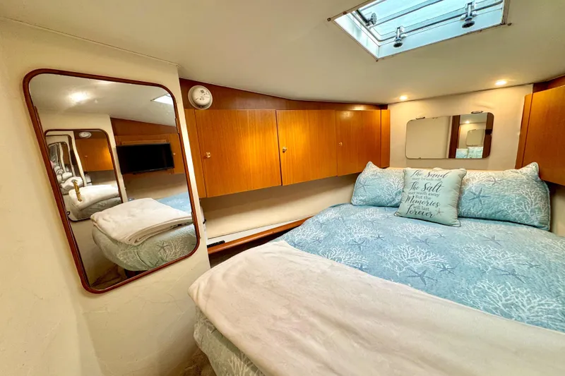 Slide: The Image of Luxurious cabin interior of 1998 Ocean Yachts 48 Super Sport with cozy bedding and wooden cabinets. - 23