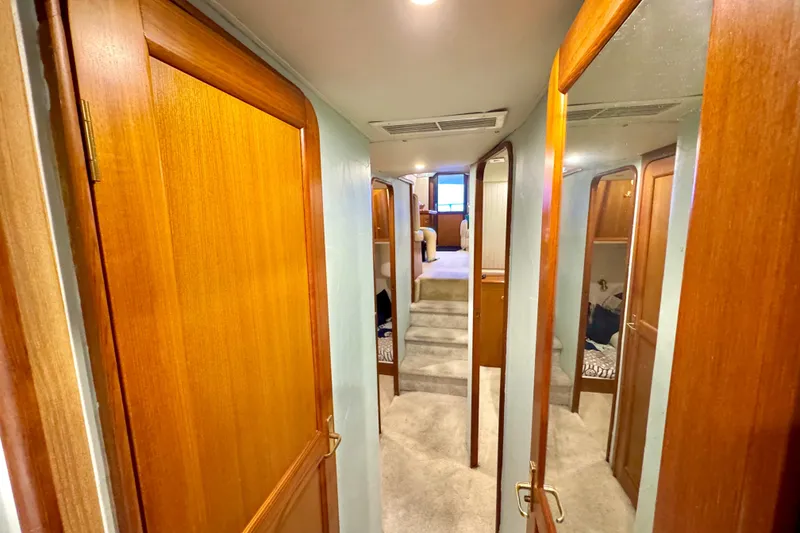 Slide: The Image of Interior hallway of 1998 Ocean Yachts 48 Super Sport with wooden doors and carpeted stairs. - 24