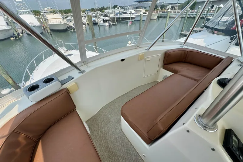 Slide: The Image of 1998 Ocean Yachts 48 Super Sport interior with brown seating, overlooking marina. - 30