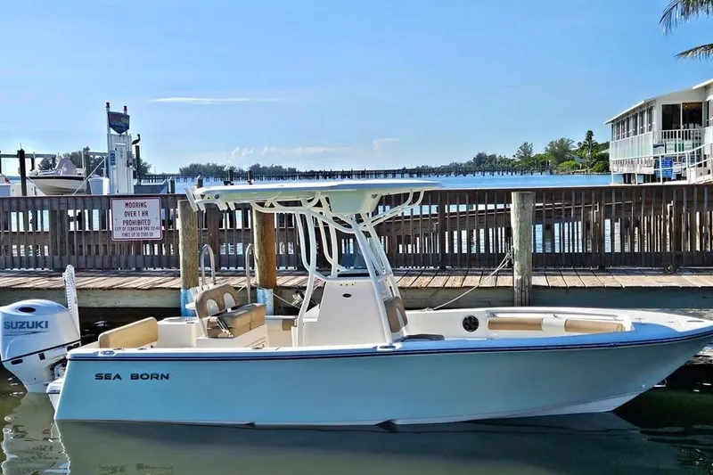 The Image of 2022 Sea Born LX22 Center Console boat docked by a wooden pier. - 0