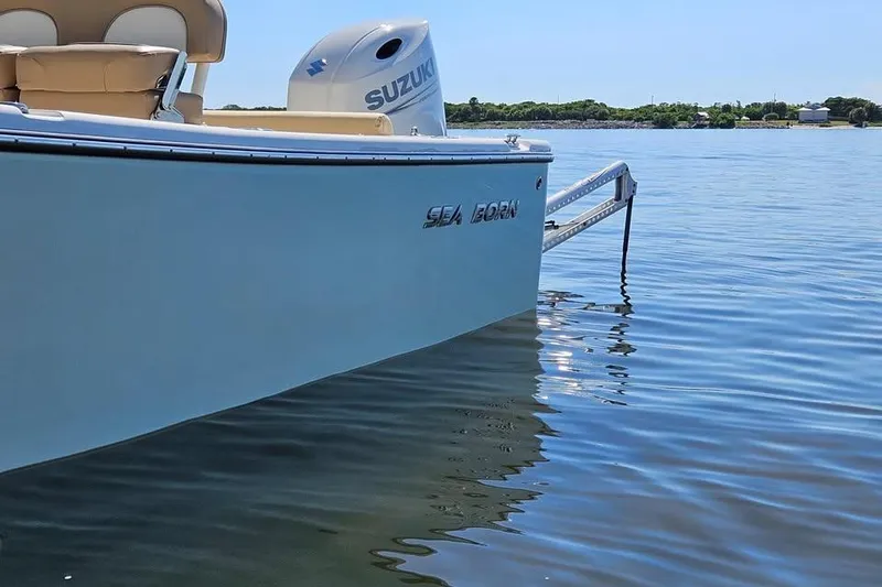 Slide: The Image of 2022 Sea Born LX22 Center Console boat on calm water with Suzuki engine. - 2
