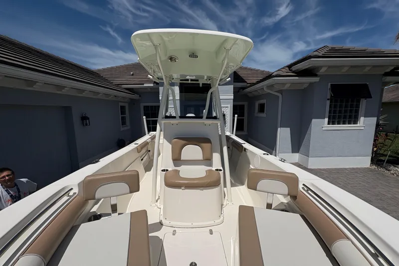Slide: The Image of 2022 Sea Born LX22 Center Console boat with tan seating, parked near a road. - 6