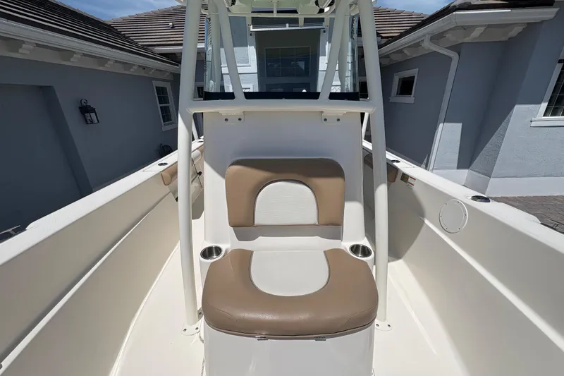 Slide: The Image of 2022 Sea Born LX22 Center Console boat with cushioned seating, parked near a road. - 7