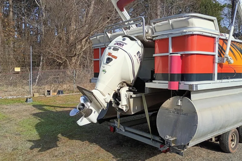 Slide: The Image of Pontoon boat with Evinrude motor, Crest 25 Ultra, 2000 model, parked on grass. - 3