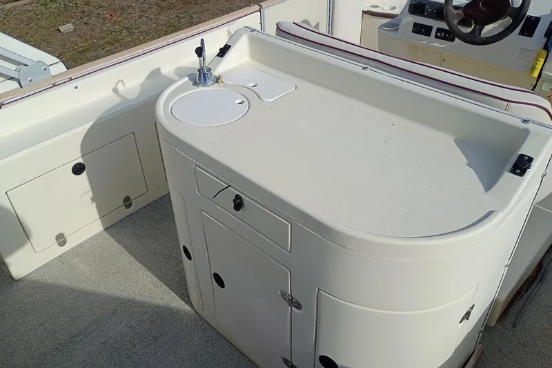 Slide: The Image of Interior view of a 2000 Crest 25 Ultra boat with a built-in sink and storage. - 9