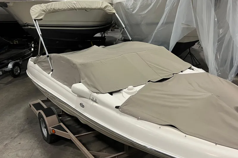 Slide: The Image of 2001 Regal 1900 LSR boat with beige cover on trailer in storage. - 13