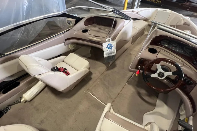 Slide: The Image of Interior of a 2001 Regal 1900 LSR boat with beige seating and wooden steering wheel. - 2
