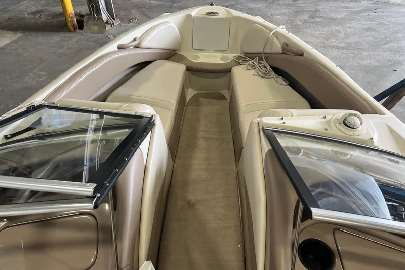 Slide: The Image of 2001 Regal 1900 LSR boat interior with beige seating and windshield in a garage setting. - 4