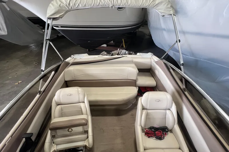 Slide: The Image of 2001 Regal 1900 LSR boat interior with beige seating and canopy in storage. - 7