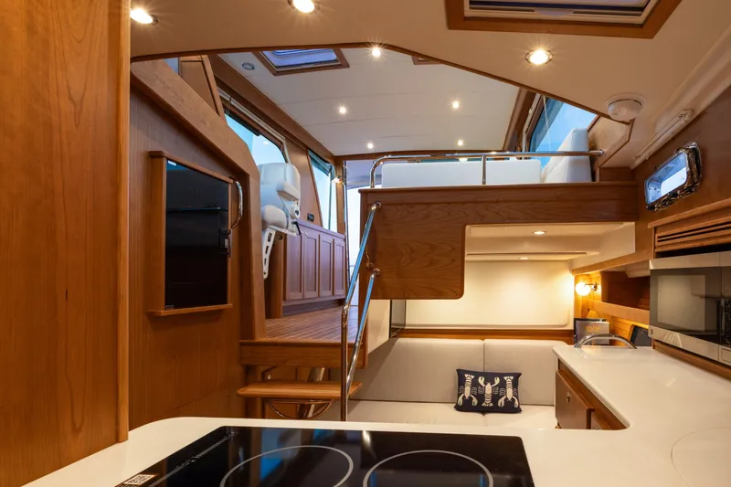 Slide: The Image of Interior of 2027 Sabre 38 Salon Express yacht, featuring modern kitchen and seating area. - 5