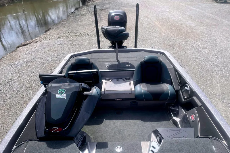 Slide: The Image of 2017 Ranger Z520 boat interior with seating and control panel near a riverbank. - 11