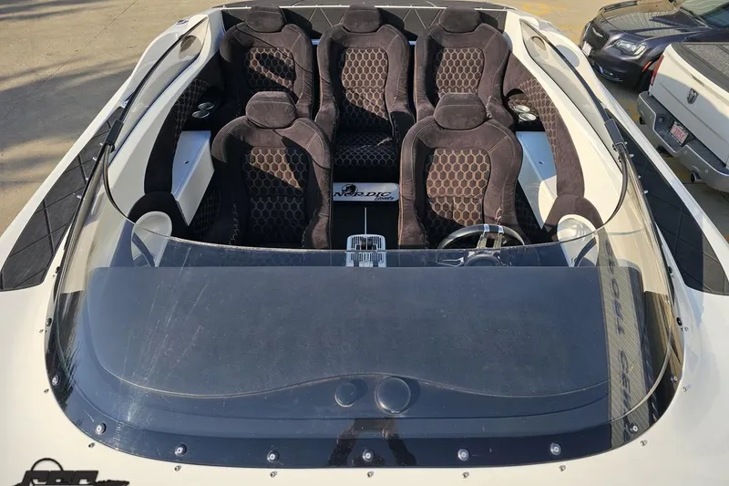 Slide: The Image of 2009 Nordic 36 Hurricane boat interior with six black seats and steering wheel. - 103