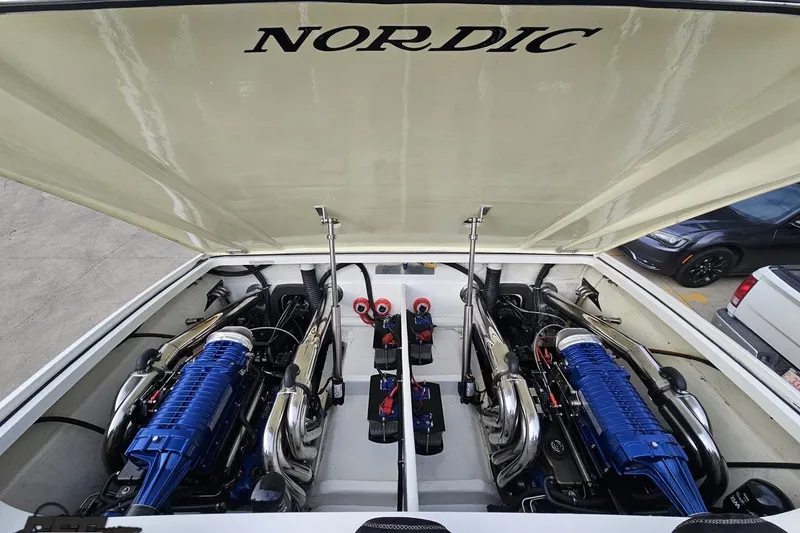 Slide: The Image of Engine compartment of a 2009 Nordic 36 Hurricane boat, showcasing dual blue engines. - 112