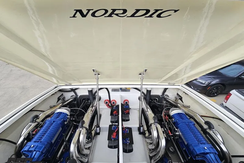 Slide: The Image of 2009 Nordic 36 Hurricane boat engine compartment with dual blue engines. - 113