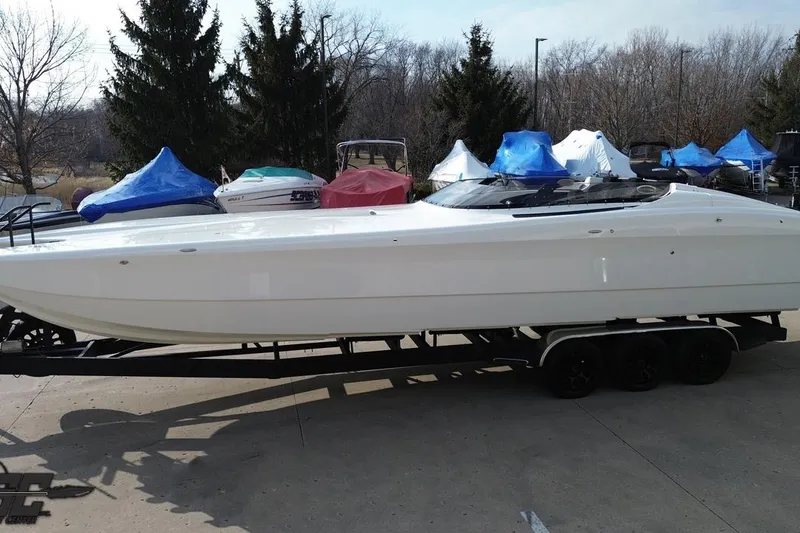 Slide: The Image of 2009 Nordic 36 Hurricane boat on trailer, parked outdoors with covered boats nearby. - 54