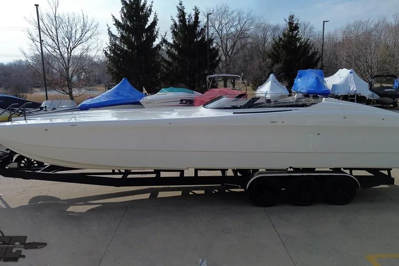 Slide: The Image of 2009 Nordic 36 Hurricane boat on trailer, parked outdoors with covered boats nearby. - 55