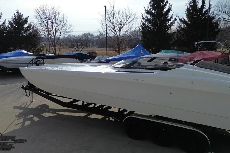 Slide: The Image of 2009 Nordic 36 Hurricane boat on trailer, surrounded by covered boats, outdoor setting. - 56