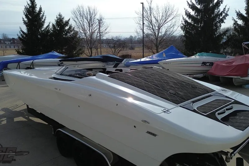 Slide: The Image of 2009 Nordic 36 Hurricane speedboat on trailer, parked outdoors with other covered boats. - 58