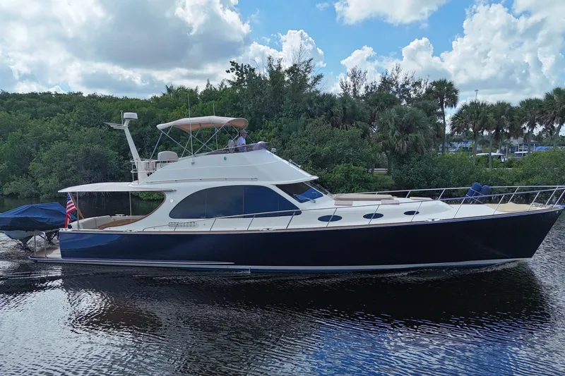 The Image of 2018 Palm Beach Motor Yachts PB55 Flybridge cruising on a serene waterway. - 0