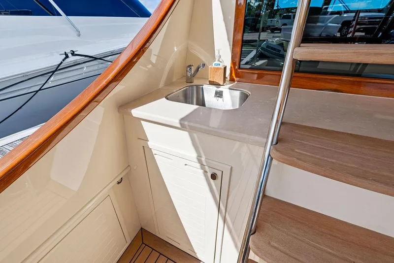 Slide: The Image of 2018 Palm Beach Motor Yachts PB55 Flybridge with sink and wooden stairs detail. - 12
