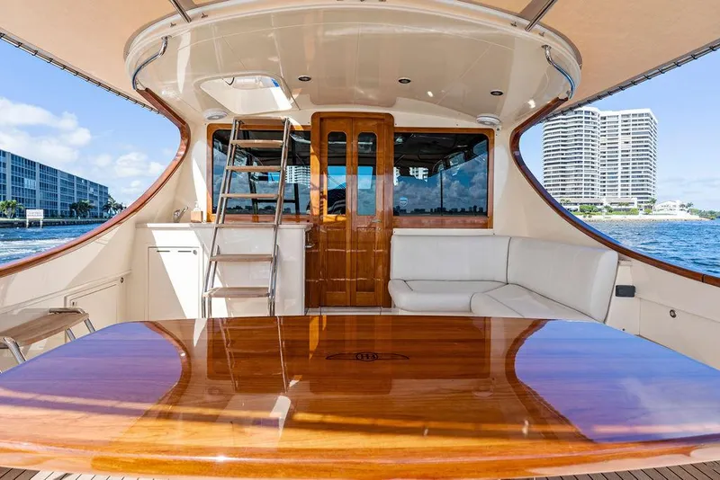 Slide: The Image of Luxurious 2018 Palm Beach Motor Yachts PB55 Flybridge with elegant wood table and waterfront view. - 16