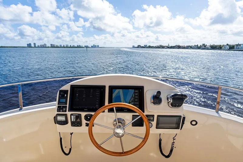 Slide: The Image of 2018 Palm Beach Motor Yachts PB55 Flybridge helm with ocean view, featuring navigation controls. - 28
