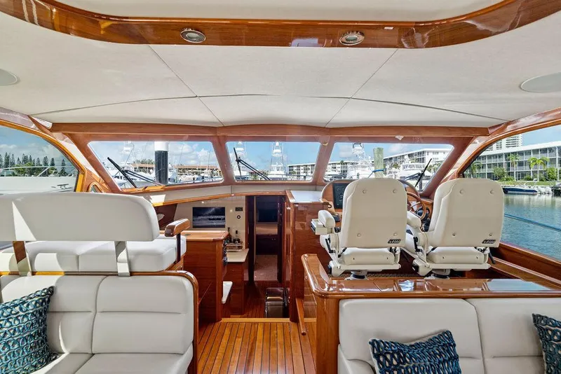 Slide: The Image of 2018 Palm Beach Motor Yachts PB55 Flybridge interior with luxurious seating and helm, docked at marina. - 33