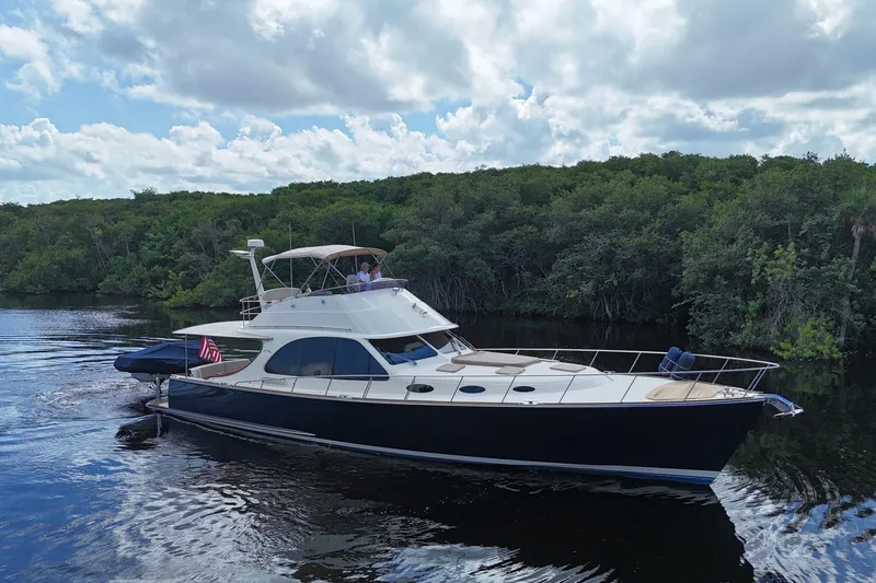 Slide: The Image of 2018 Palm Beach Motor Yachts PB55 Flybridge cruising on a serene waterway. - 67