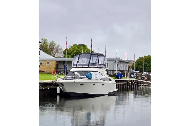 Slide: The Image of 2001 Regal Commodore 3780 yacht docked at a marina with flags and buildings. - 1