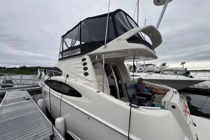 Slide: The Image of 2001 Regal Commodore 3780 yacht docked, featuring a person relaxing on the deck. - 10
