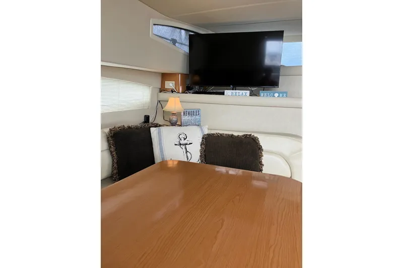 Slide: The Image of Interior of 2001 Regal Commodore 3780 yacht with TV, cushions, and wooden table. - 31