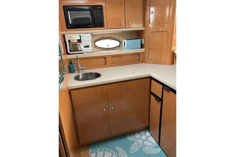 Slide: The Image of 2001 Regal Commodore 3780 yacht kitchen with microwave, sink, and storage cabinets. - 32