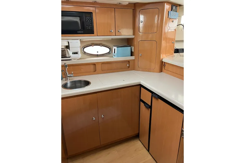 Slide: The Image of 2001 Regal Commodore 3780 yacht kitchen with wood cabinets, sink, and appliances. - 33