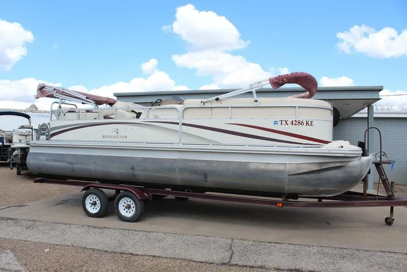 The Image of 2005 Bennington 2275 RL pontoon boat on trailer under blue sky. - 1