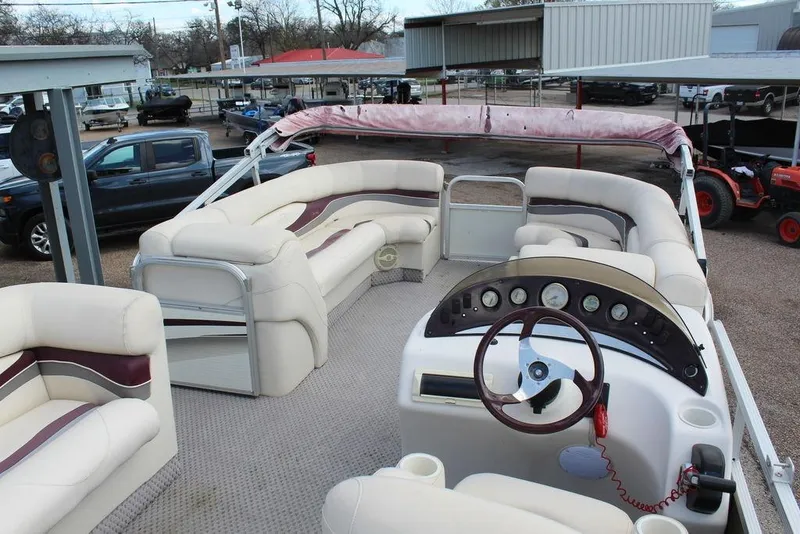 Slide: The Image of 2005 Bennington 2275 RL pontoon boat interior with plush seating and steering console. - 9