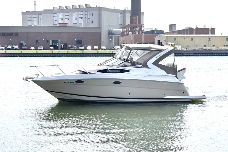 The Image of 2013 Regal 30 Express boat docked in an industrial waterfront setting. - 0
