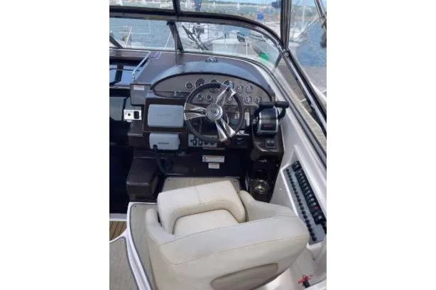 Slide: The Image of 2013 Regal 30 Express boat cockpit with steering wheel and control panel. - 13