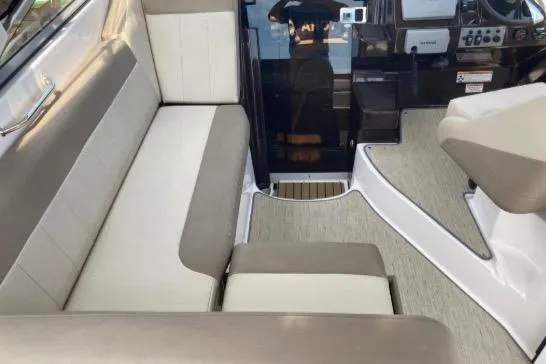 Slide: The Image of Interior of 2013 Regal 30 Express boat, featuring beige and white seating. - 16