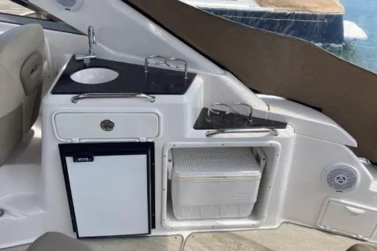 Slide: The Image of 2013 Regal 30 Express boat interior with sink, mini fridge, and storage compartment. - 17